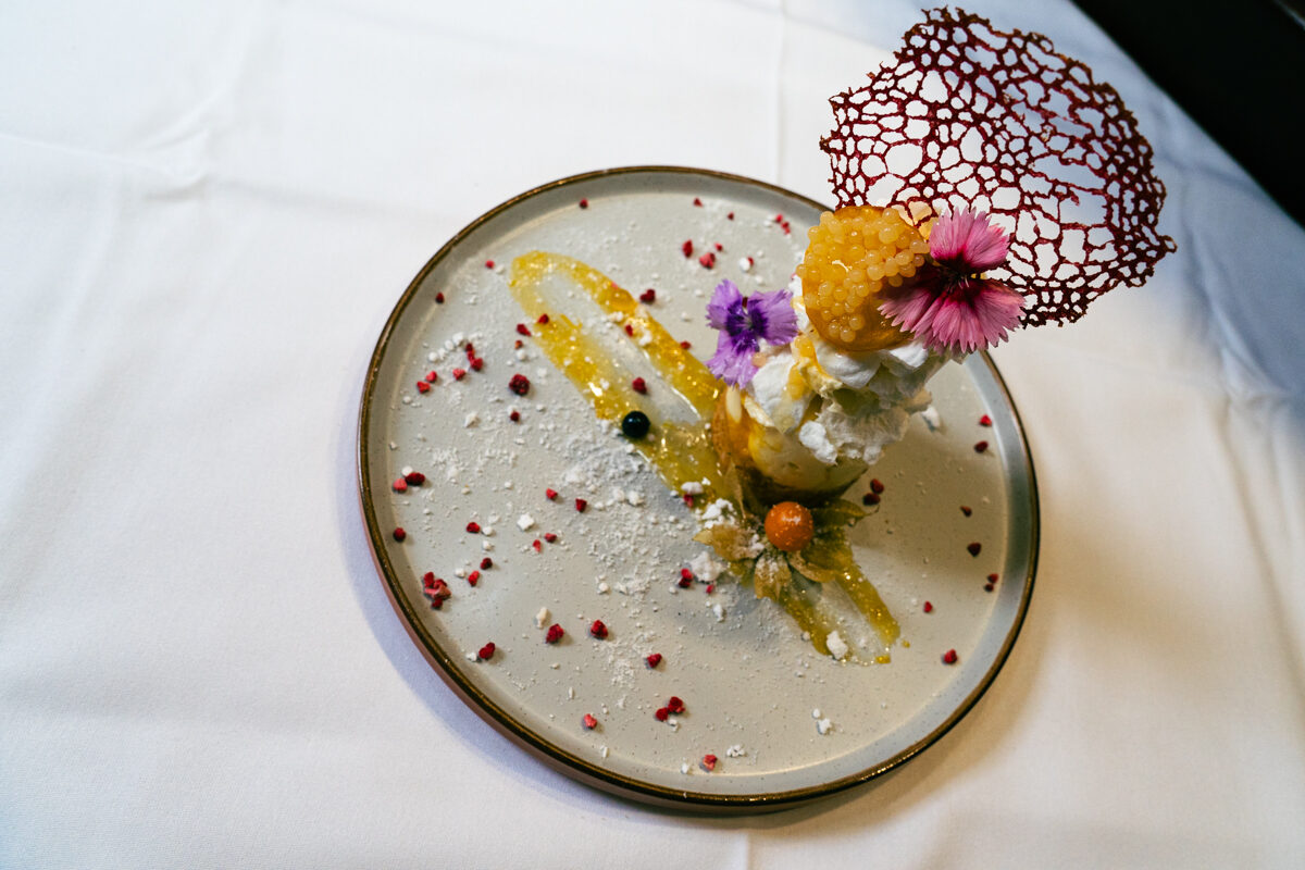 A dessert finished with edible flowers and a sugar tuile.